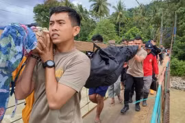 Des secouristes transportent le corps d'une personne décédée dans le glissement de terrain du village de Tulabolo, en Indonésie, le 9 juillet. (Photo : AFP)