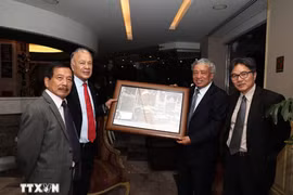 L'ancien directeur général de l'Agence vietnamienne d’Information (VNA) Tran Mai Huong (2e, droite)offre un cadeau de souvenir au secrétaire général du PT, Alberto Anaya Gutiérrez,. Photo : VNA