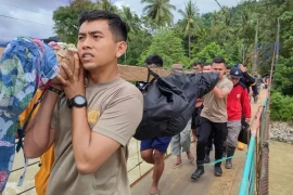 Des secouristes transportent le corps d'une personne décédée dans le glissement de terrain du village de Tulabolo, en Indonésie, le 9 juillet. (Photo : AFP)