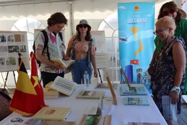 Des visiteurs s'intéressent au livre du feu secrétaire général du Parti Nguyen Phu Trong sur la théorie et la pratique de la voie vers le socialisme au Vietnam. Photo : VNA
