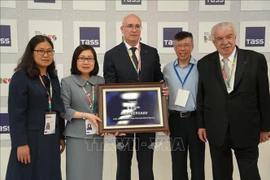 La directrice générale adjointe de la VNA Doan Thi Tuyet Nhung (2e, gauche) offre un souvenir au directeur général de l'agence de presse TASS, Andrey Kondrashov. Photo : VNA
