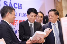 Luong Cuong, membre du Bureau politique, permanent du Secrétariat (centre) et Nguyen Trong Nghia, membre du Bureau politique, secrétaire du Comité central du Parti et chef de la Commission centrale de propagande et d'éducation (droite) lors de la zone d'exposition de livres. Photo : VNA