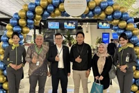 Un représentant de Vietnam Airlines en Indonésie (troisième à partir de la gauche) avec des passagers à l'aéroport international Soekarno-Hatta, en Indonésie. Photo : VNA