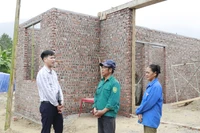 Un fonctionnaire de la commune de Viêt Hông (province de Lao Cai) inspectent l'avancement des travaux de construction de la maison des habitants. Photo: VNA