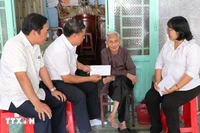 Remise des cadeaux du Parti et de l'État aux bénéficiaires à leur domicile. Photo: VNA