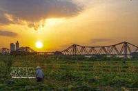 Le pont Long Biên au coucher du soleil. Photo: VNA