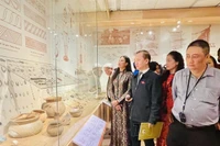 Des visiteurs admirent des artefacts mis au jour sur le site archéologique de Vuon Chuôi, au Musée de Hanoi. Photo : VNA