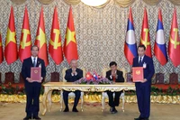 Le secrétaire général du Parti communiste du Vietnam, Tô Lâm, et le secrétaire général du Parti révolutionnaire populaire lao et président lao, Thongloun Sisoulith supervisent l’échange des accords de coopération entre les deux pays. Photo : VNA