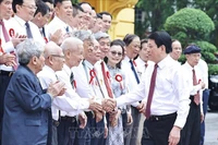 Le président Luong Cuong serre la main des journalistes chevronnés, à Hanoi, le 20 juin. Photo : VNA