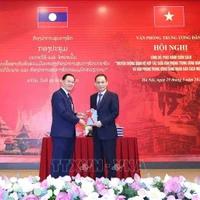 Le Hoai Trung (droite), secrétaire du Comité central du PCV et chef du Bureau du Comité central du PCV, offre un exemplaire du livre à Thongsalith Mangnomek, secrétaire du Comité central du PPRL et chef du Bureau du Comité central du PPRL. Photo : VNA