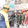 Les secouristes vietnamiens à la recherche de victimes dans les décombres. Photo: VNA 