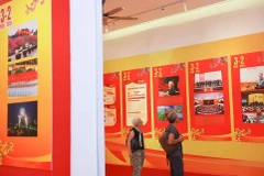 Des visiteurs internationaux visitent une exposition sur le Parti à Hanoi à l'occasion du 95e anniversaire de la fondation du Parti communiste du Vietnam. Photo: VNA