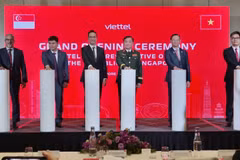 Le général de corps d'armée Hoang Xuan Chien, membre de la Permanence de la Commission militaire centrale et vice-ministre de la Défense (3e de droite à gauche), et d'autres délégués, appuient sur le bouton inaugurant le bureau de représentation de Viettel à Singapour. Photot: VNA
