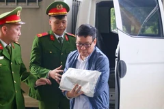 L'ancien président du Comité populaire de l'ancienne province de Vinh Phuc, Le Duy Thanh, est escorté au tribunal. Photo : anninhthudo.vn