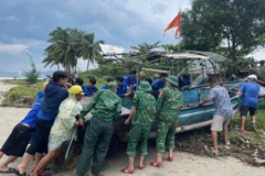 Les membres de l'Union de la jeunesse du district de Lien Chieu, à Da Nang, soutiennent les gens qui ramèneront des bateaux-paniers à terre en octobre 2024. Photo : VNA