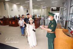 Des gardes-frontières du poste frontière international de Mong Cai procèdent aux formalités de sortie des passagers. Photo : VNA