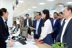 Le Premier ministre Pham Minh Chinh (en chemise bleue) visite le Centre de services administratifs publics de Quang Ninh. Photo: VNA