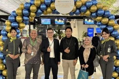 Un représentant de Vietnam Airlines en Indonésie (troisième à partir de la gauche) avec des passagers à l'aéroport international Soekarno-Hatta, en Indonésie. Photo : VNA