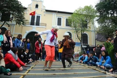 Les visiteurs internationaux découvrent des activités culturelles et des jeux folkloriques à Hanoi. (Photo : Thanh Dat/https://nhandan.vn/)