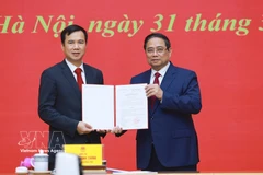 Le Premier ministre Pham Minh Chinh (à droite) remet la décision de nomination de Bui The Duy, membre suppléant du Comité central du Parti et vice-président de l’Académie des sciences et des technologies du Vietnam, au poste de directeur de l’Université nationale du Vietnam à Hanoï. Photo : VNA