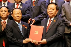 Nguyen Trong Nghia (à droite), membre du Bureau Politique, secrétaire du Comité central du Parti, chef de la Commission centrale de la mobilisation auprès de masse et de l’éducation remet la décision nommant Thai Dai Ngoc secrétaire provincial du Parti de Gia Lai pour la période 2025-2030. Photo : VNA