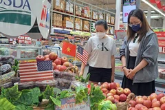 Des consommateurs choisissent des pommes américaines dans un supermarché à Hô Chi Minh-Ville. Photo : nld.com.vn