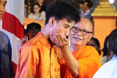 Le rituel d’offrande du côm dep, sorte de jeune riz gluant aplati, est une spécialité khmère en l’honneur de la Lune. Photo : VNA