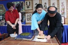 Des visiteurs expérimentent l’impression des estampes populaires de Dông Hô. Photo: VNA