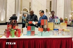 Le Phu Cuong (au milieu), conseiller commercial vietnamien en Malaisie, présente des produits vietnamiens lors d'une foire en Malaisie. Photo : VNA