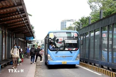 Des passagers prennent un bus dans la rue Ham Nghi, à Hô Chi Minh-Ville. Photo: VNA