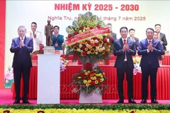 Le secrétaire général du Parti Tô Lâm (gauche) offre un panier de fleurs pour féliciter le Congrès des organisations du Parti de la commune de Nghia Tru pour le mandat 2025-2030. Photo : VNA