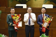 Le président de l'Assemblée nationale, Trân Thanh Mân (au centre) remet l'Insigne « Pour la cause de l'Assemblée nationale vietnamienne » au ministre des Sciences et Technologies, Nguyen Manh Hung (à droite), et au président-directeur général du groupe de l'industrie militaire et des télécommunications (Viettel), Tao Duc Thang. Photo : VNA