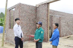Un fonctionnaire de la commune de Viêt Hông (province de Lao Cai) inspectent l'avancement des travaux de construction de la maison des habitants. Photo: VNA