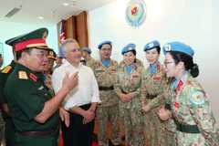 Le général de corps d’armée Hoàng Xuân Chiên, vice-ministre de la Défense et chef du Comité de pilotage du ministère sur la participation aux opérations de maintien de la paix de l’ONU, et Hugh Jeffrey, secrétaire général adjoint à la Défense de l’Australie échangent avec des femmes officiers de la Force vietnamienne de maintien de la paix. Photo : VNA