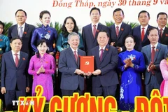 Nguyên Trong Nghia (troisième de droite à gauche), membre du Politburo, secrétaire du Comité central du Parti, chef de la Commission centrale de la sensibilisation et de l'éducation et et de mobilisation de masse du Parti, a présenté la décision au nouveau secrétaire du Comité provincial du Parti de Dông Thap, Ngô Chi Cuong. Photo: VNA