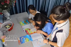 Des collaborateurs sociaux accompagnent T.A.T. (née en 2013) dans ses activités d’apprentissage et de vie quotidienne au sein de la maison d’accueil temporaire du modèle "Bồ Công Anh", située dans le quartier de Hạnh Thong, à Hô Chi Minh-Ville. Photo: VNA