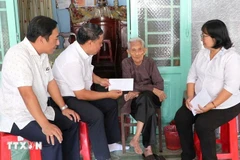 Remise des cadeaux du Parti et de l'État aux bénéficiaires à leur domicile. Photo: VNA