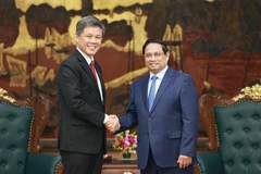 Le Premier ministre vietnamien Pham Minh Chinh (à droite) et Chan Chun Sing, vice-secrétaire général du Parti d’action populaire (PAP), ministre coordinateur des Services publics et ministre de la Défense de Singapour, en visite de travail au Vietnam. Photo : VNA