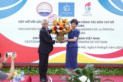 Le représentant de l'agence de presse Prensa Latina au Vietnam offert des fleurs à la directrice générale de VNA, Vu Viêt Trang à l'occasion de la Journée de la presse révolutionnaire vietnamienne. Photo : VNA