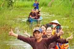 Les visiteurs apprécient les balades en pirogue à travers la forêt, au sein d’un site de tourisme écologique dans la région de la forêt d’U Minh Hạ. Photo: VNA