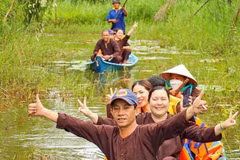 Les visiteurs apprécient les balades en pirogue à travers la forêt, au sein d’un site de tourisme écologique dans la région de la forêt d’U Minh Hạ. Photo: VNA