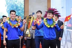 Le capitaine Do Duy Manh (droite) et Nguyen Tien Linh apportent le trophée de la Coupe de l'ASEAN 2024 à la rencontre avec le Premier ministre Pham Minh Chinh. Photo: VNA