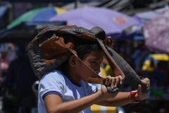 Un élève utilise un sac à dos pour se protéger du soleil à Manille, aux Philippines en avril 2024. Photo : AFP