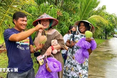 Des visiteurs se montrent enthousiastes à l’idée de participer à l’expérience de cueillette de mangues dans les vergers de la commune de Cam Lam. Photo: VNA