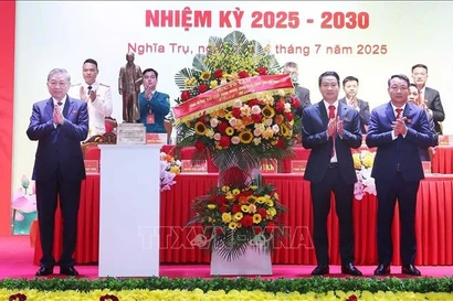Le secrétaire général du Parti Tô Lâm (gauche) offre un panier de fleurs pour féliciter le Congrès des organisations du Parti de la commune de Nghia Tru pour le mandat 2025-2030. Photo : VNA