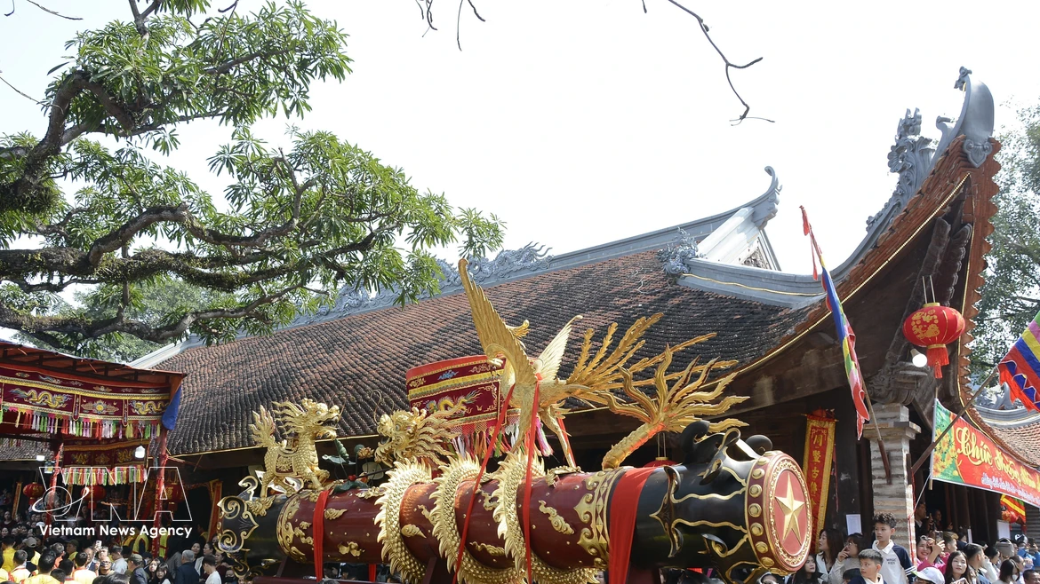 La fête de procession des pétards du village de Dông Ky comprend deux parties : la procession de deux pétards énormes, décorés de dragons et de phénix créés par les lignées familiales prestigieuses de la région dans la cour de la maison communale, et le rite "Bousculade des mandarins de la procession". Photo: VNA