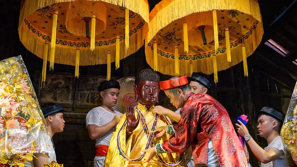 Exécution du rituel de l''habillage du Bouddha", l'un des rites uniques et rares encore préservés à la fête du village Keo. Photo: VNA