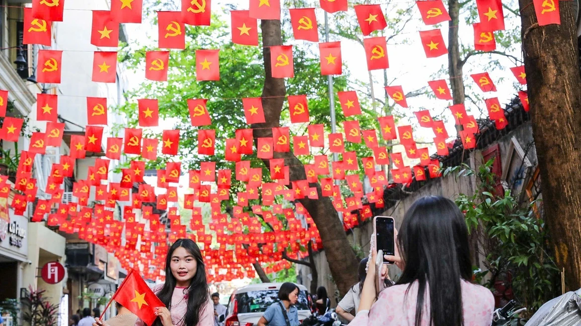 Les gens affluent dans les rues bordées de drapeaux pour prendre des photos, répandant ainsi la fierté nationale avant la grande fête nationale. Photo: VNA