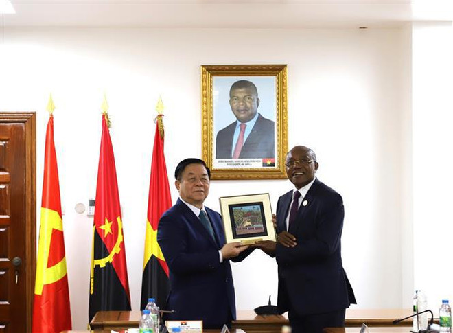 Le secrétaire du Comité central du Parti et chef de la Commission centrale de la sensibilisation et de l'éducation, Nguyen Trong Nghia (gauche), offre un cadeau à Manuel Domigos Augusto, secrétaire chargé des relations internationales du MPLA. Photo: VNA 3.jpg