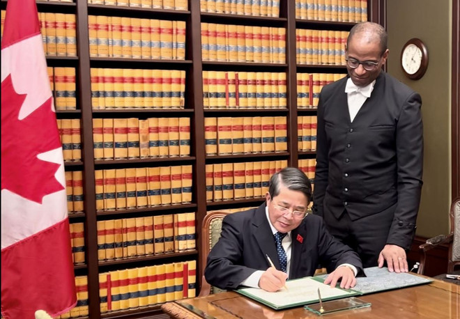 Le vice-président de l'AN Nguyen Duc Hai (à gauche) écrit dans un livre souvenir lors d'une rencontre avec le président de la Chambre des communes du Canada, Greg Fegus. Photo: VNA Hai.jpeg